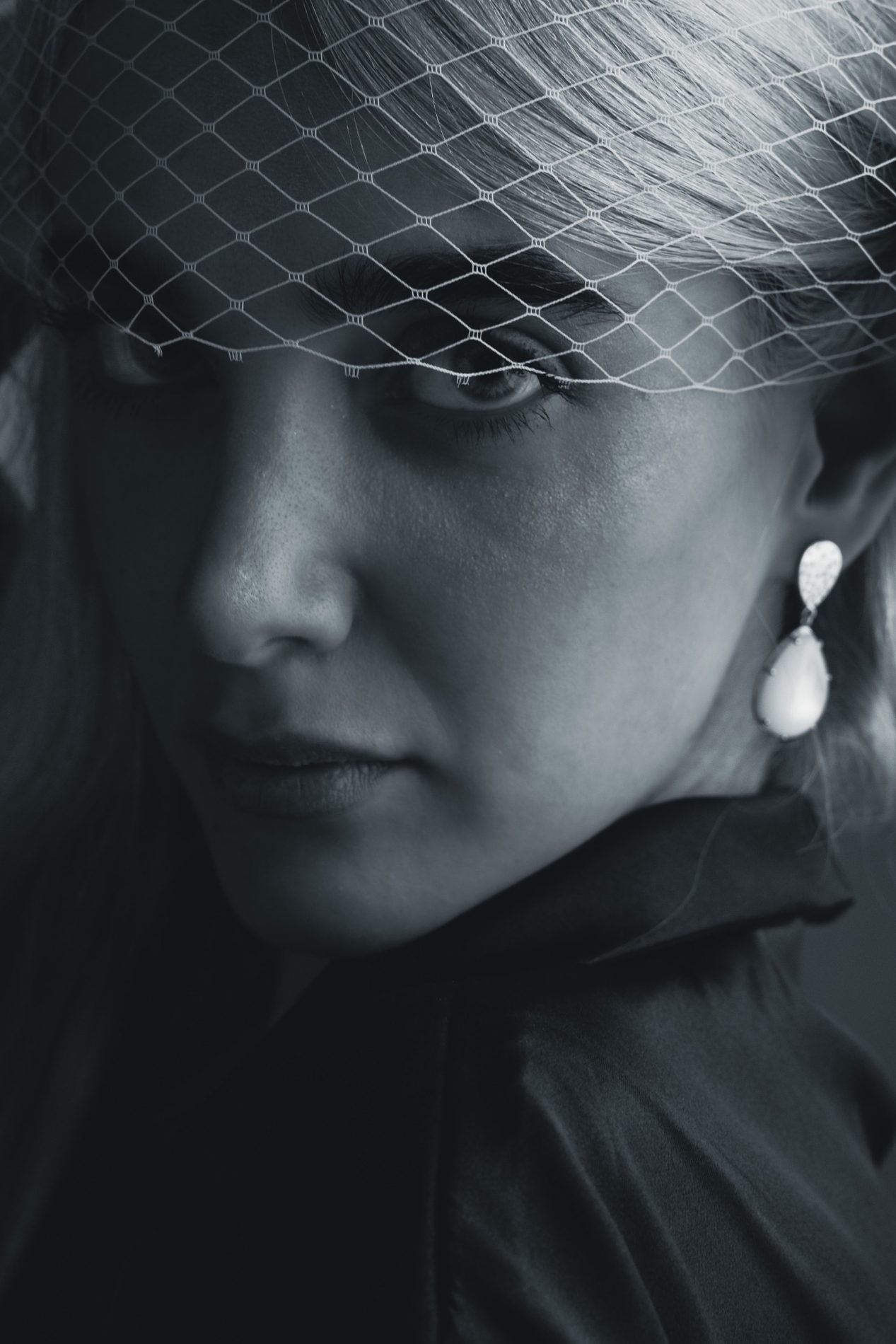 Black and white jewelry editorial portrait with veil and pearl earring